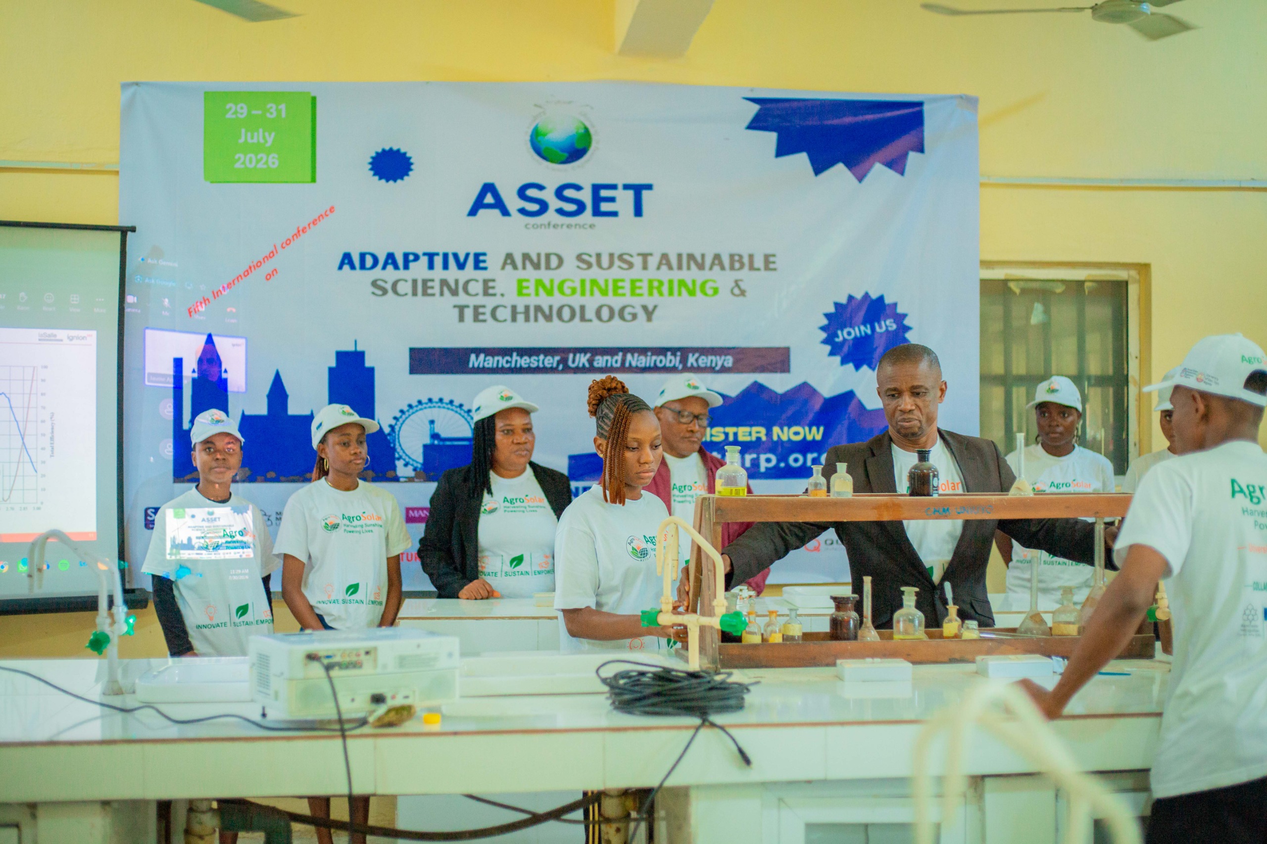 AgroSolar team gathered around a laboratory bench with glassware in front of an ASSET conference banner